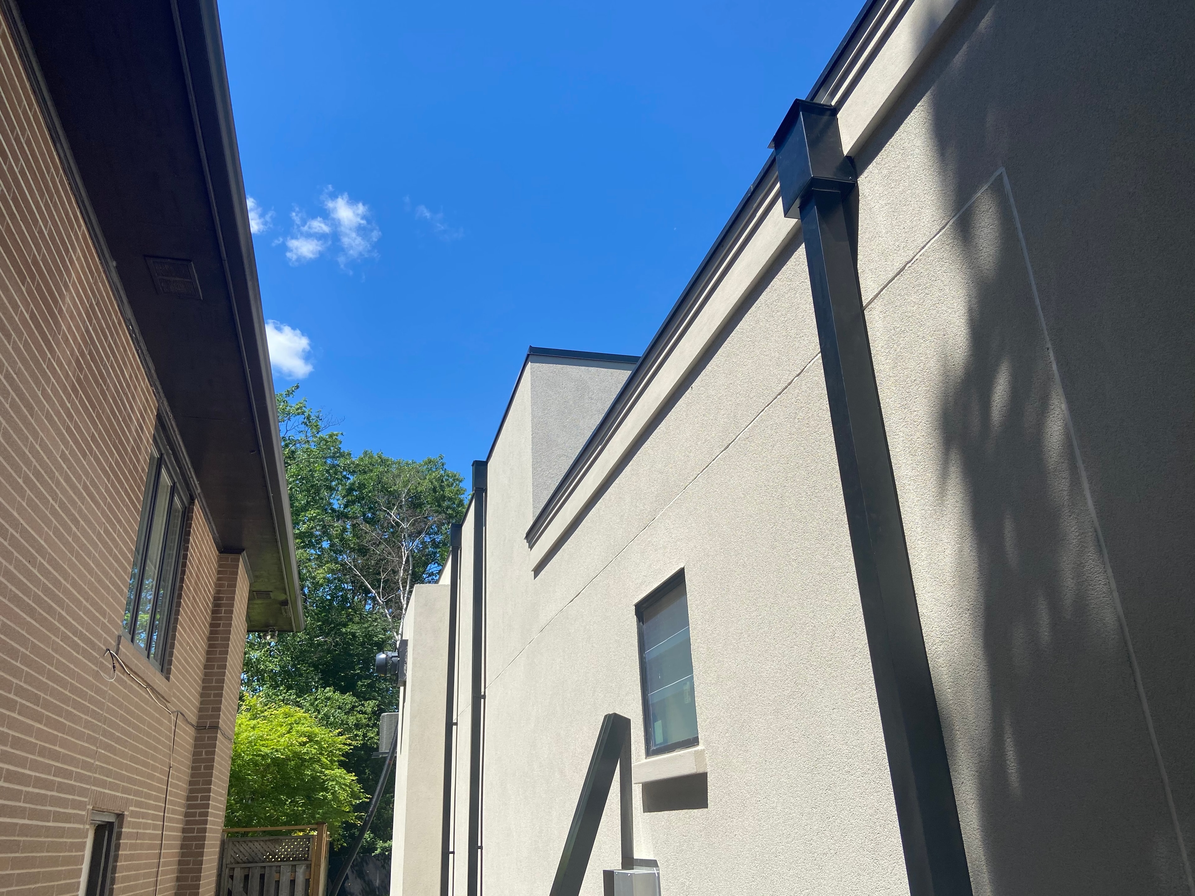 Dark Metal Eavestrough & Downpipe — Stucco Building, Summer — Primus Sheet Metal Corp. GTA