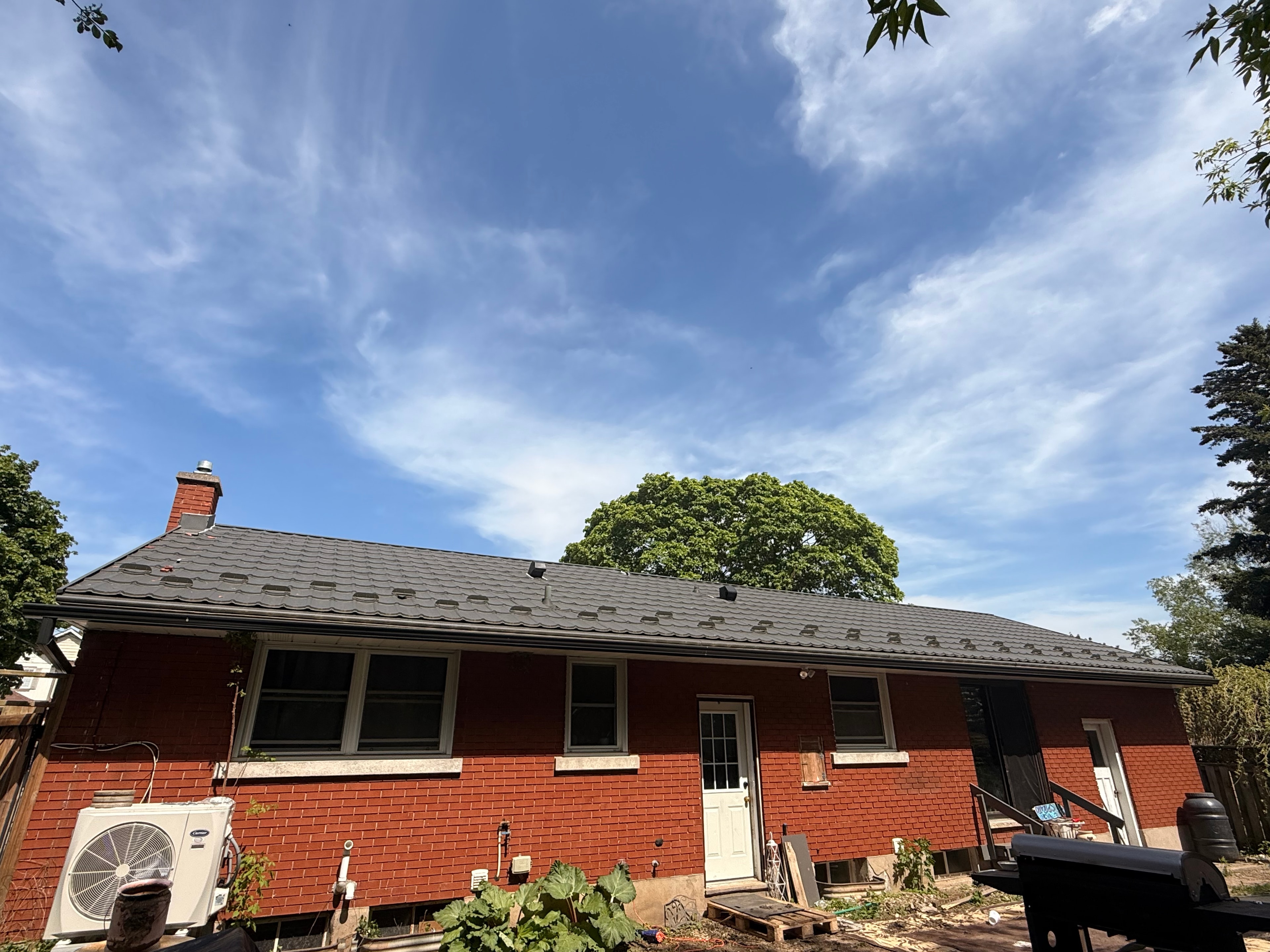 Dark eavestrough corner — residential brick facade, GTA