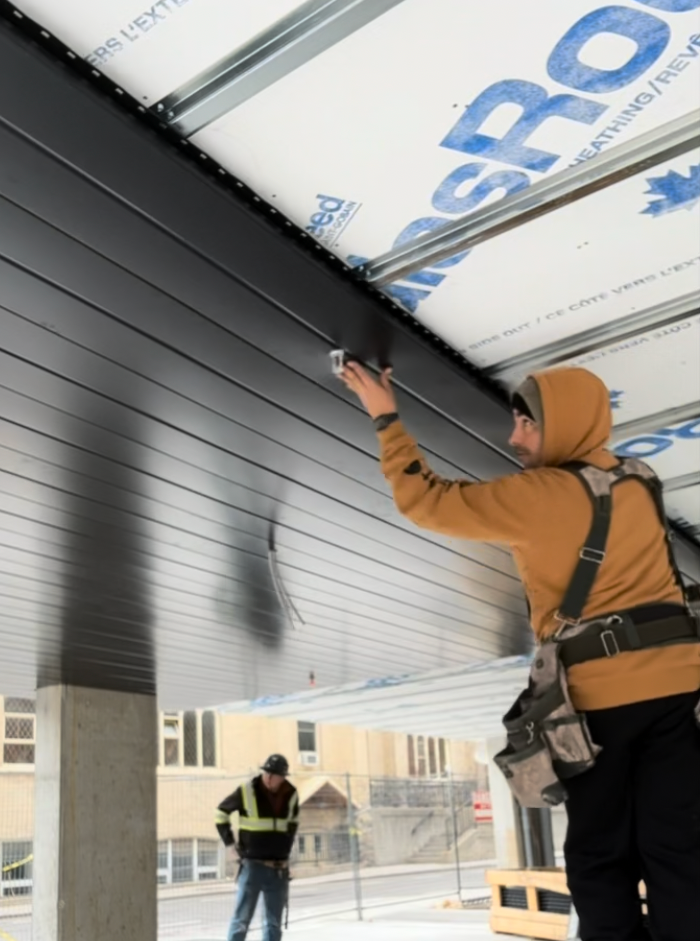 Dark metal soffit — close-up panel installation, commercial canopy, GTA